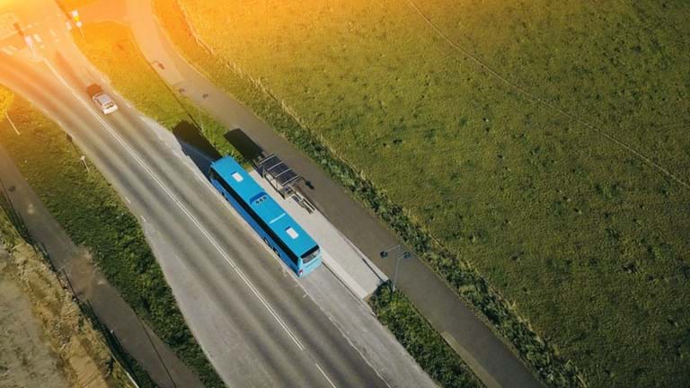 A drone-bild of a bus in a landscape